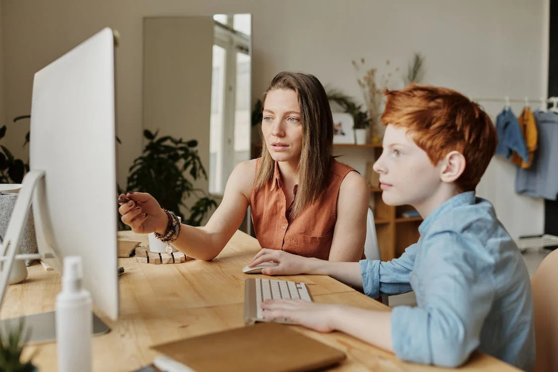 Mother talking to son while facing computer screen