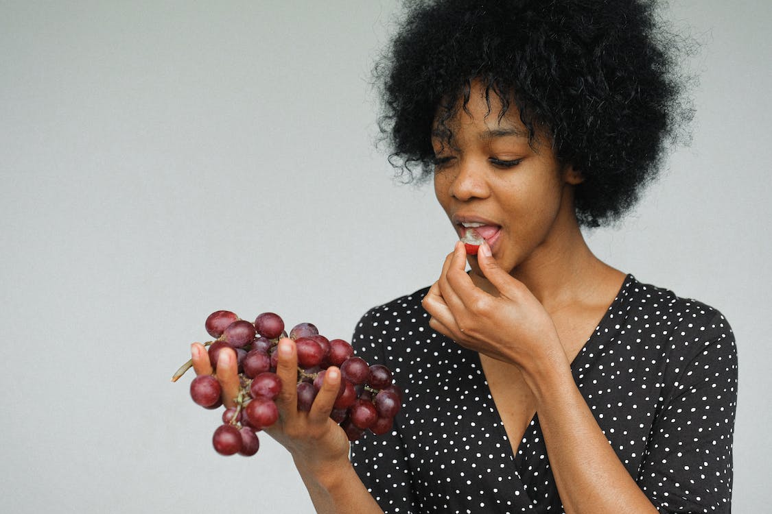 A woman eating grapes