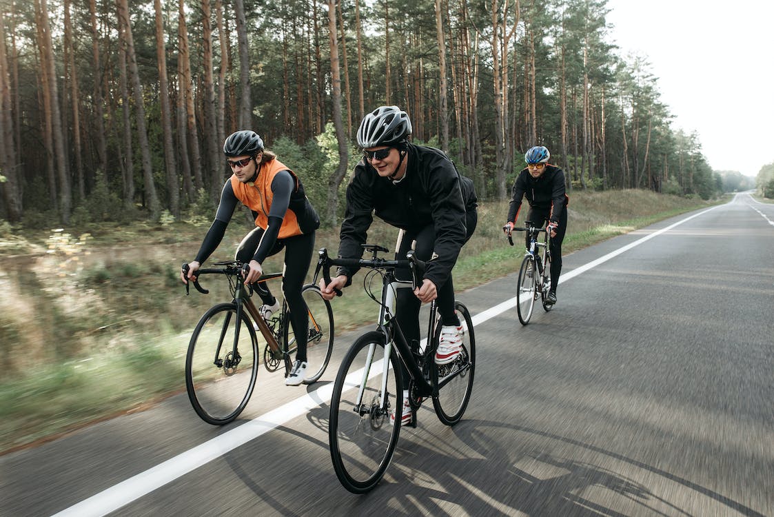 Three people biking on the road