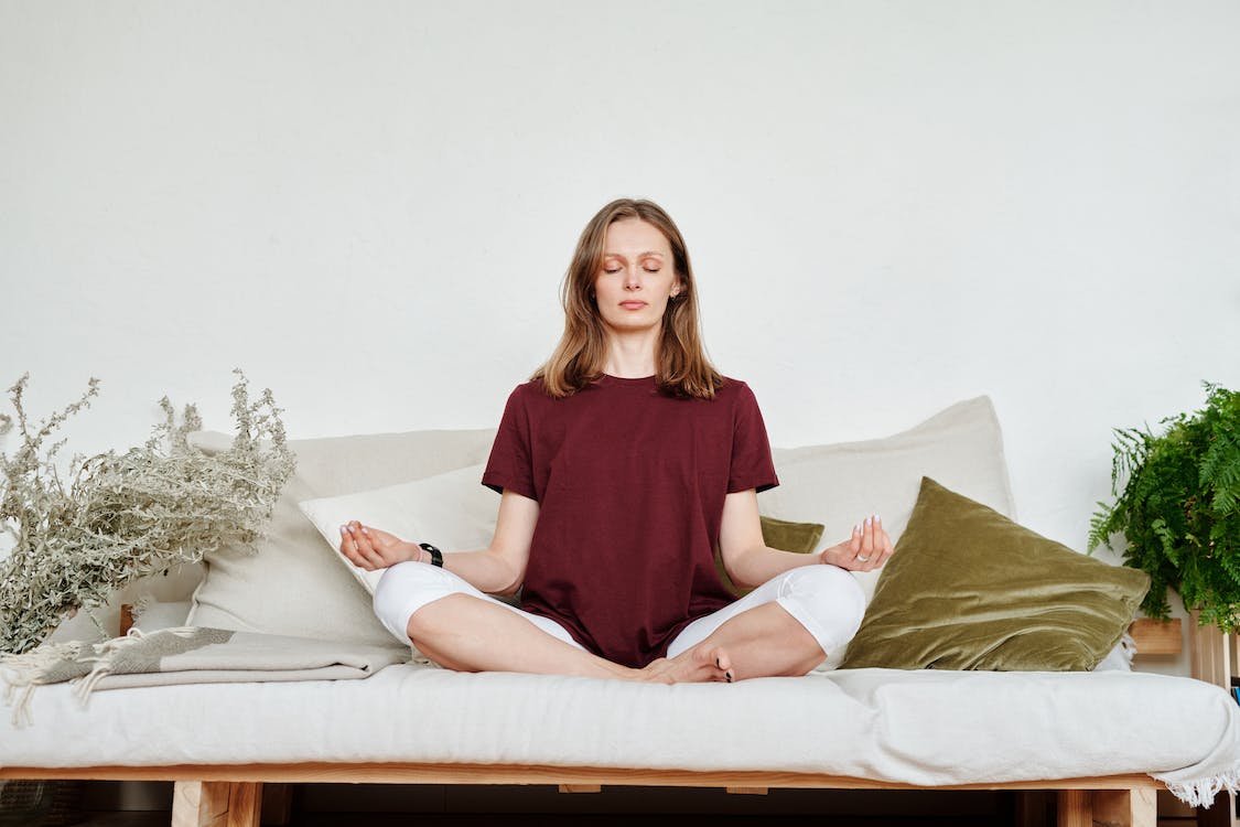 Woman meditating on sofa