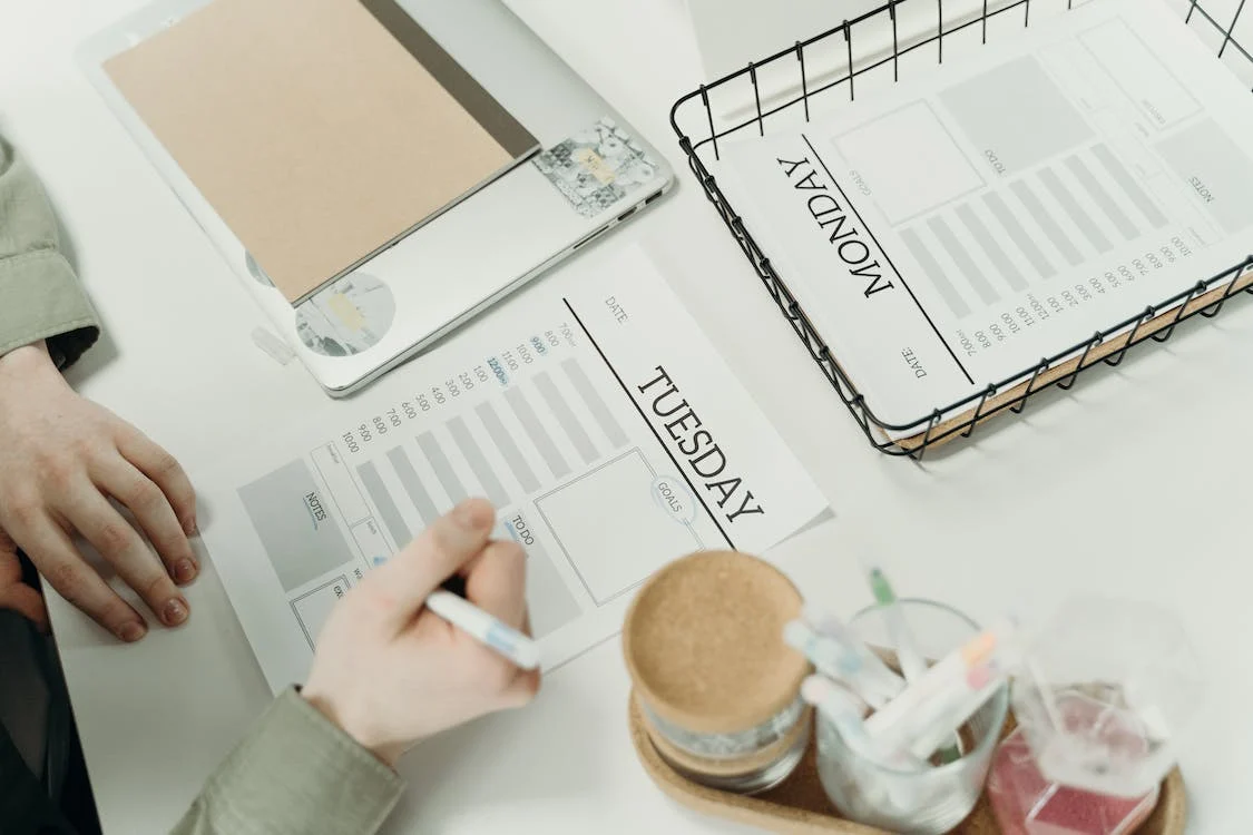 Person writing on daily planner