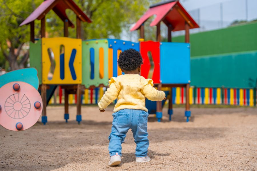 rear view of a little girl walking on playground