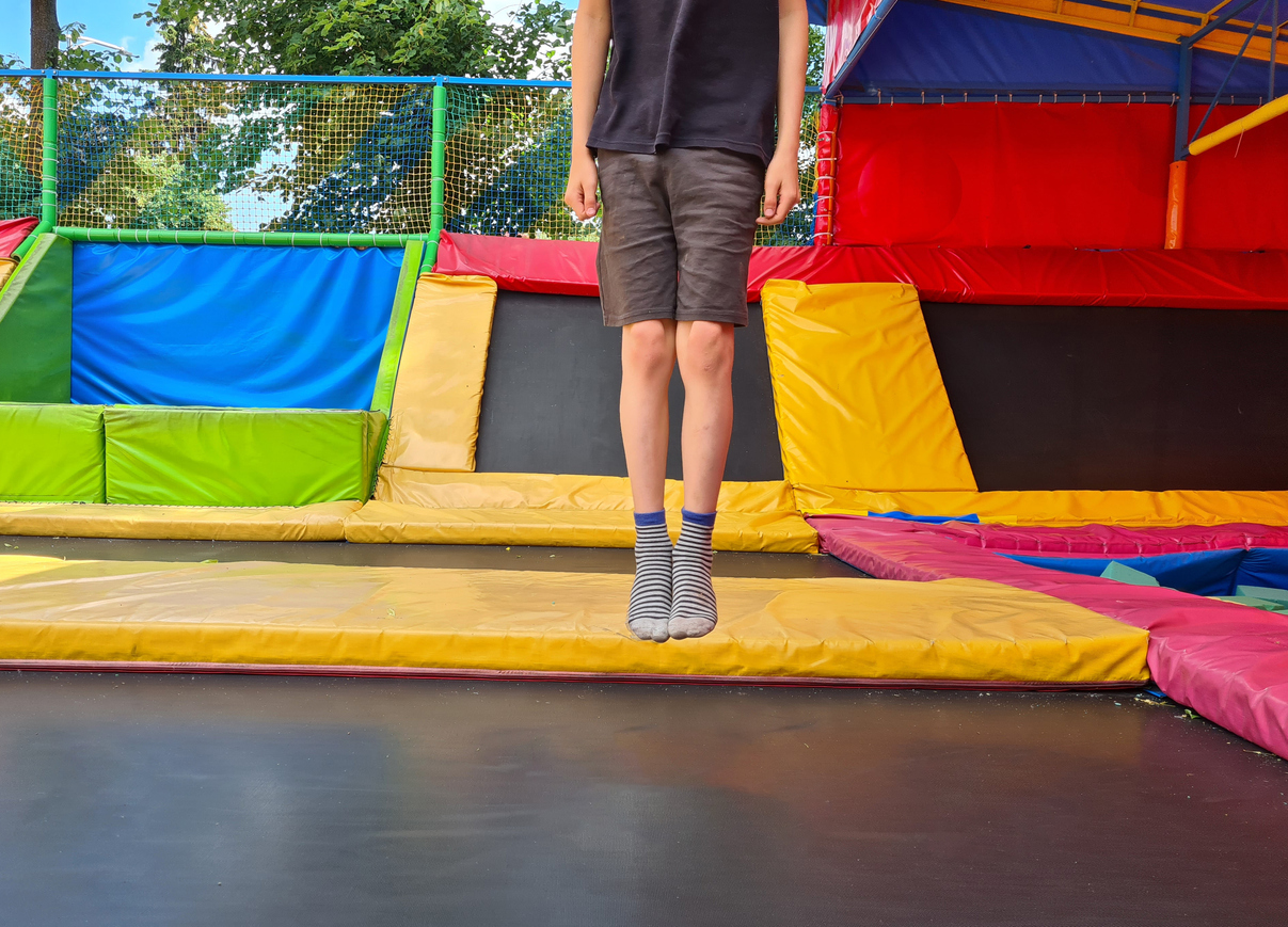 Children jumping on trampoline and having fun in park