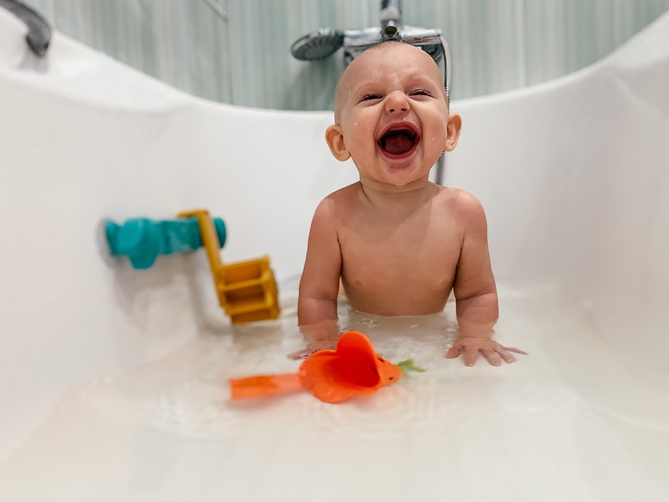 A happy baby bathing on a tub