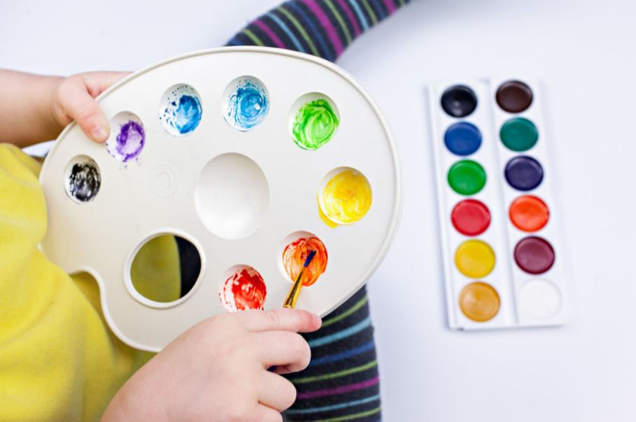 crop-child-mixing-watercolor-paints-in-palette