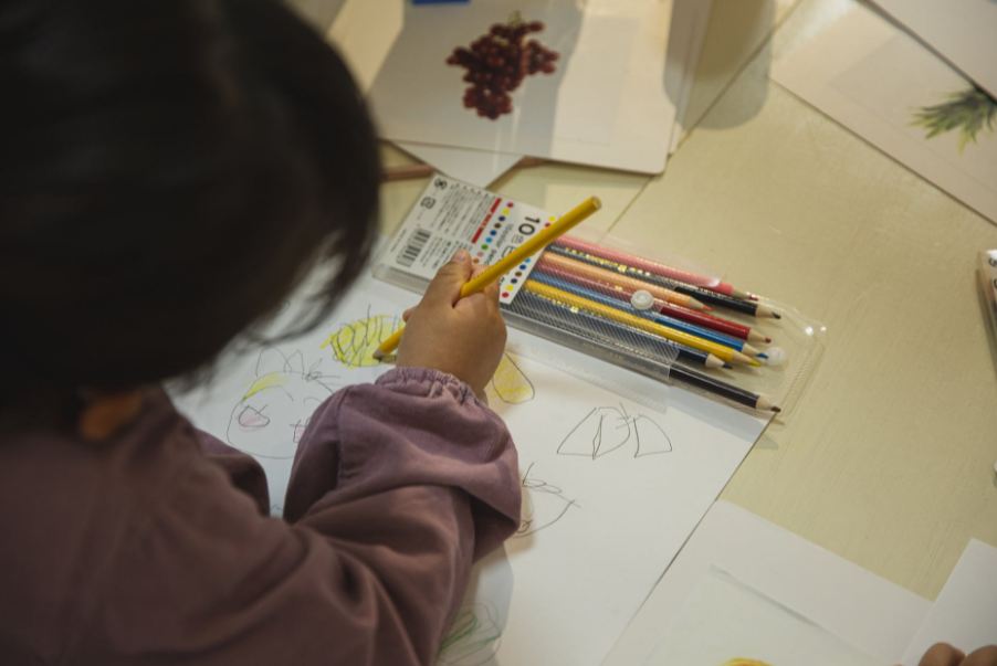 crop-ethnic-child-coloring-drawing-with-pencil