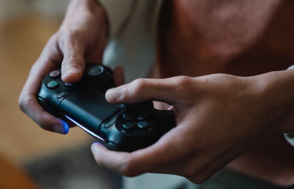 crop-gamer-with-joystick-playing-video-game-at-home