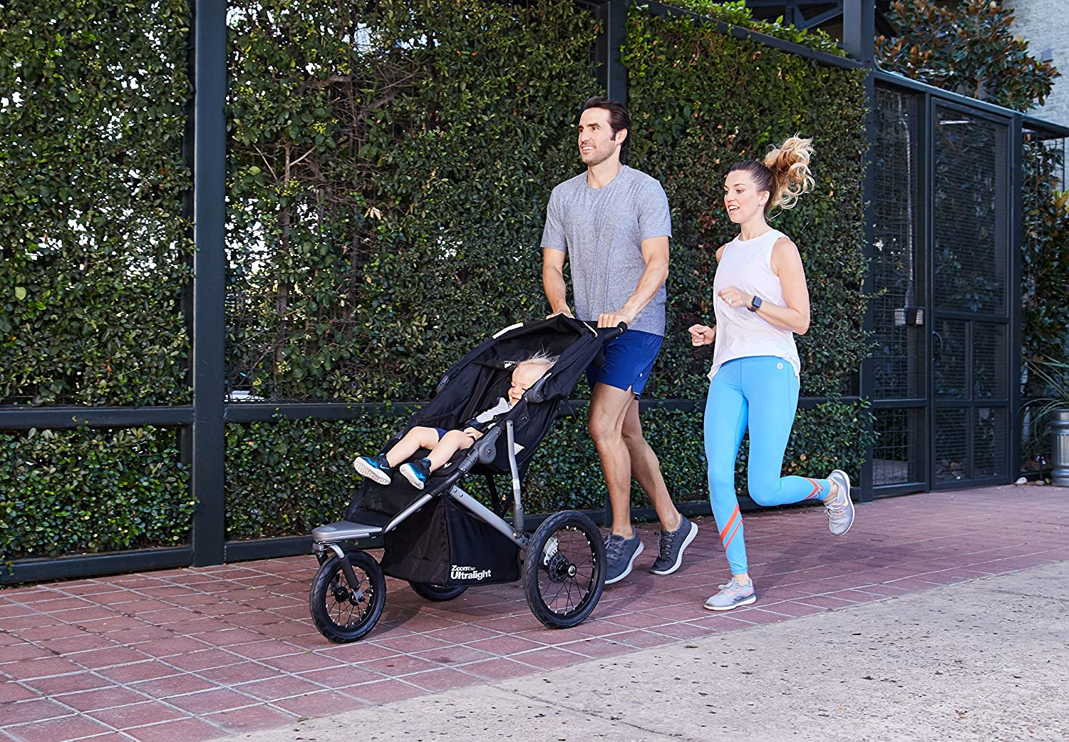 a couple jogging holding a jogging stroller