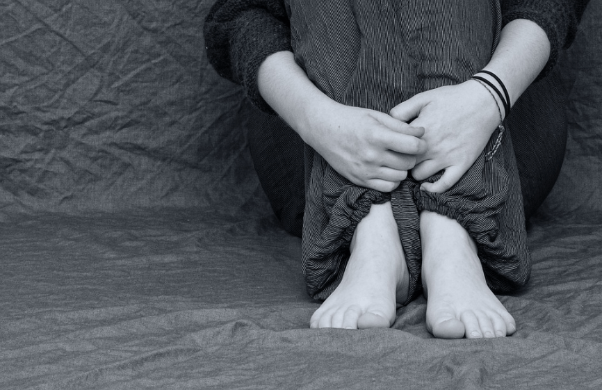 person sitting with hand and legs together