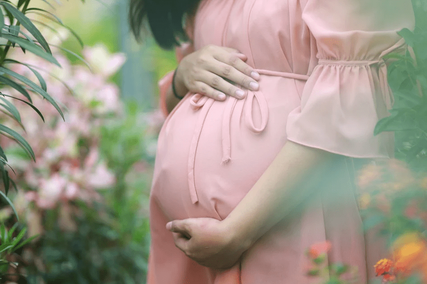 a pregnant woman surrounded by flowers
