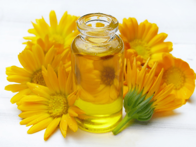 vial of essential oil, yellow flowers