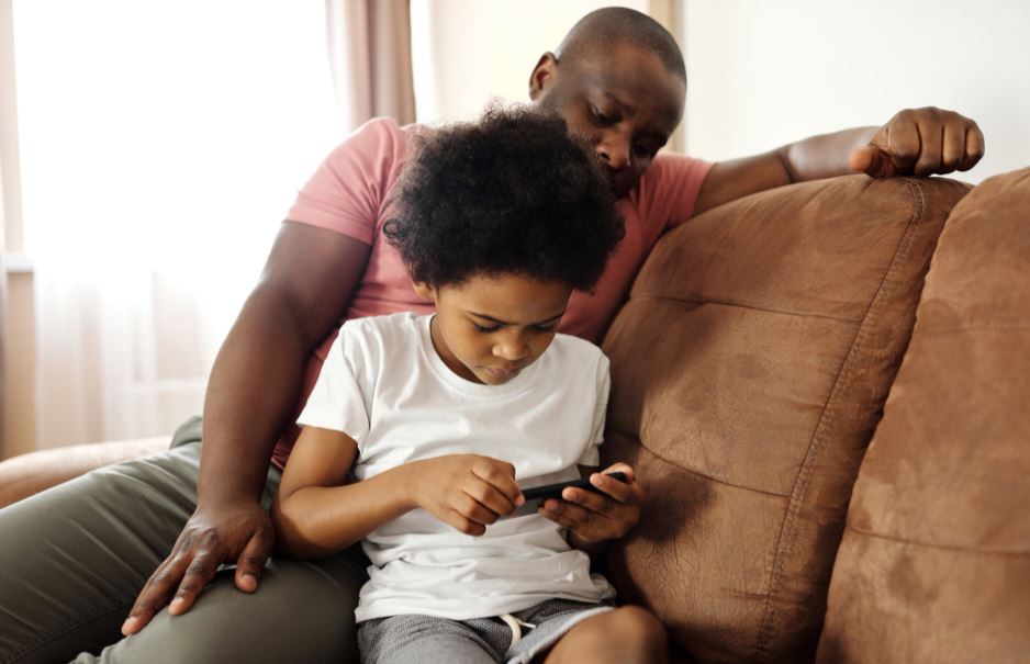 father-looking-at-his-son-playing-on-a-smartphone