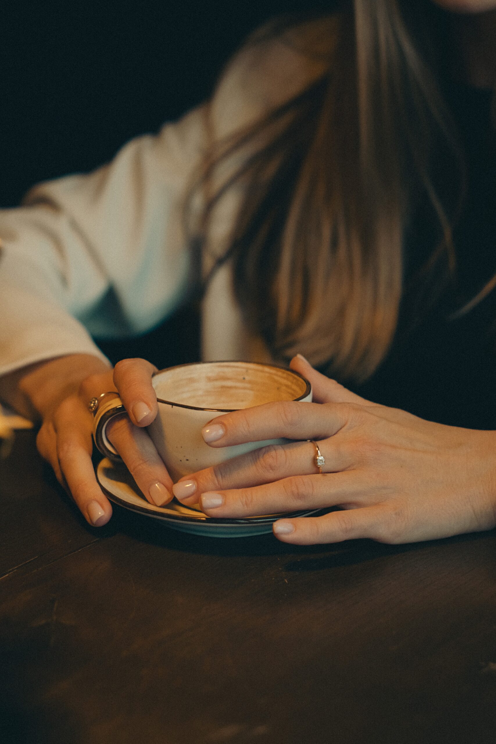 close-up-of-woman-sitting-at-cafe-table-with-coffee-cup