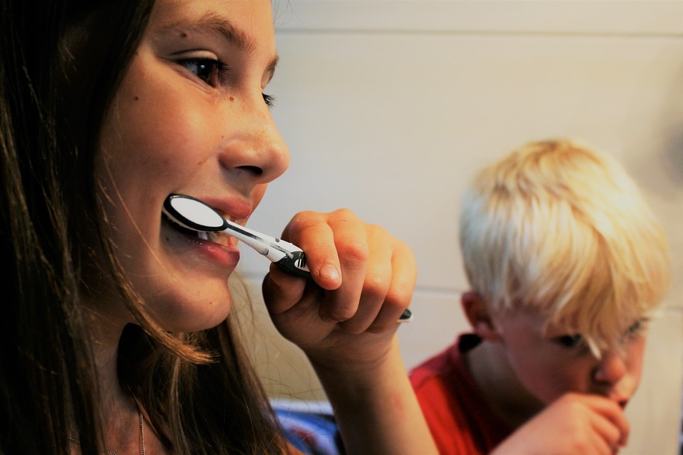 mother and son brushing their teeth together 