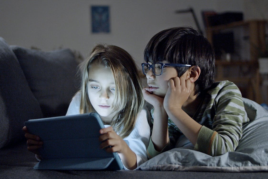 Kids looking at a tablet at bedtime