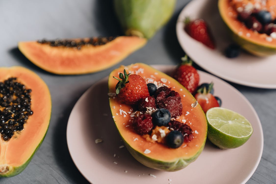 Sliced papaya with colorful berries on top